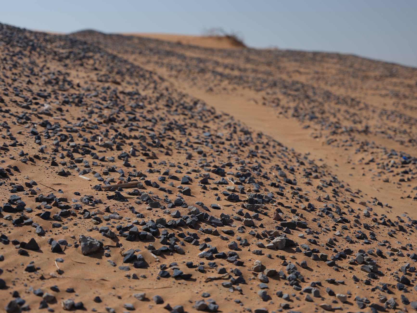 Fire agate rough stones scattered on desert sand