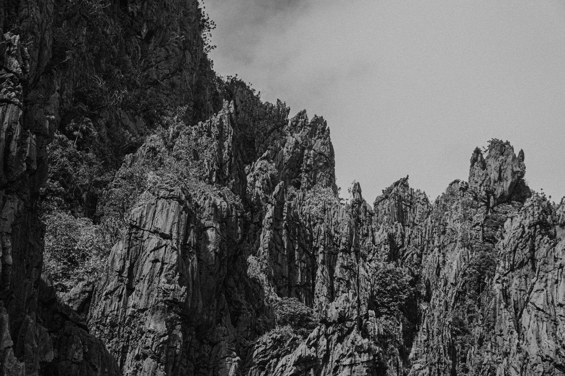 A stunning black and white photograph of rugged rocky cliffs under a clear sky.