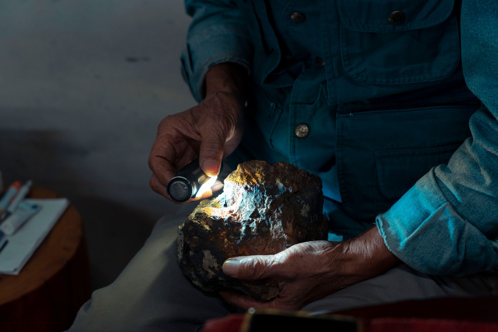 mineral collector using a hand lens on a turquoise specimen