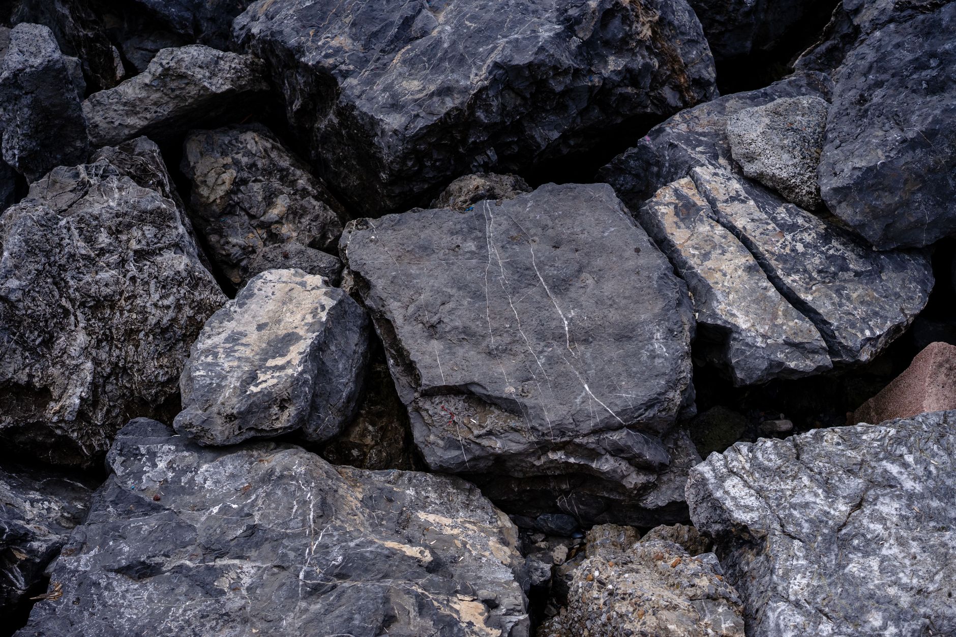 rock hammer and safety glasses resting on rocky ground at a collecting site